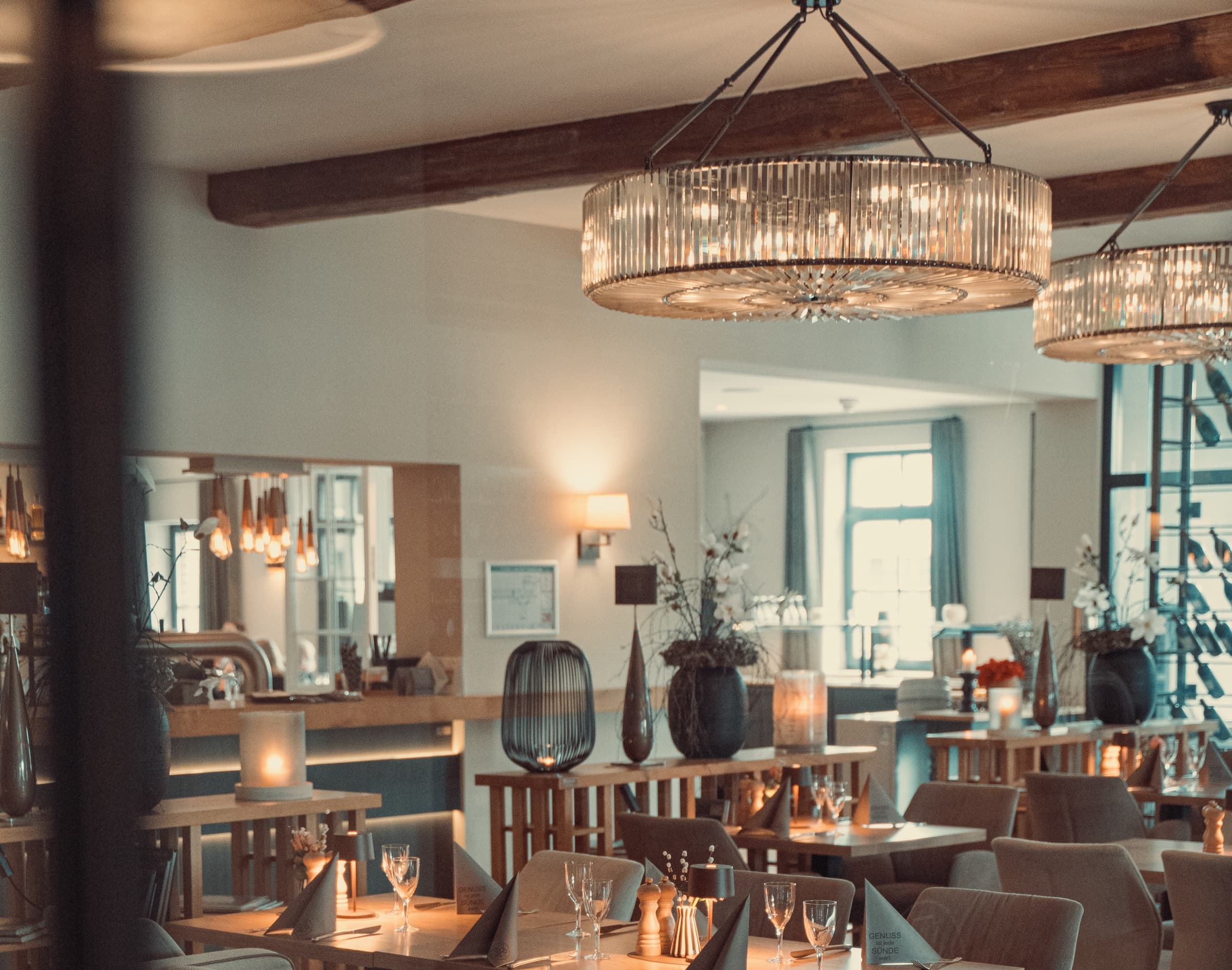 Restaurant im Patentkrug mit Kristallleuchtern, Bar und gedeckten Tischen